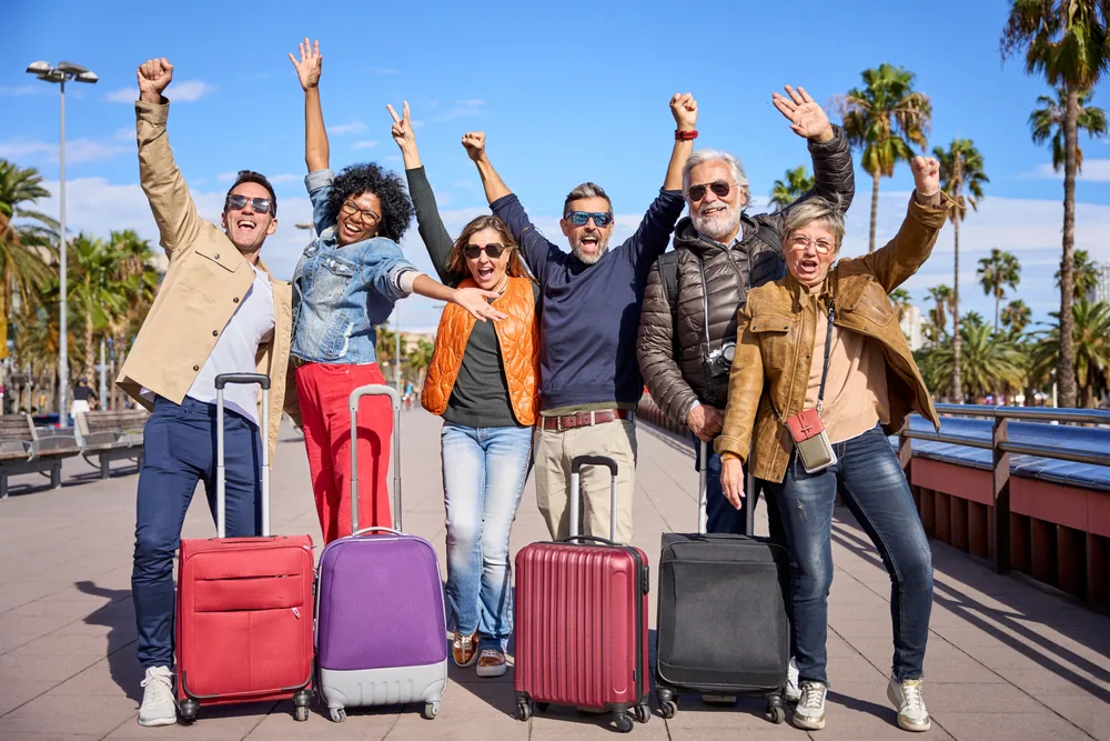 Fröhliche Reisegruppe mit Koffern